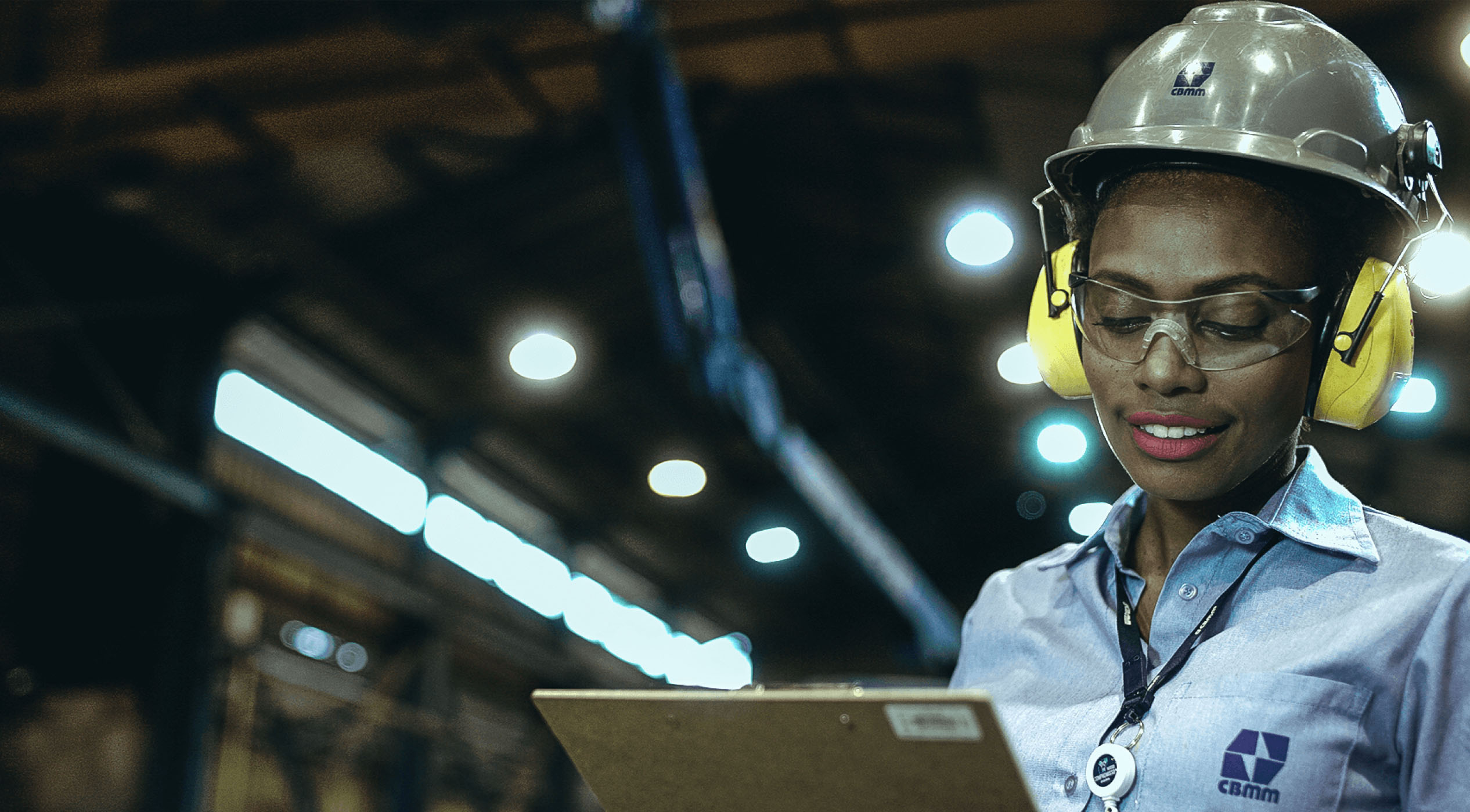 CBMM employee with clipboard in hand, uniform, protective helmet and ear protector