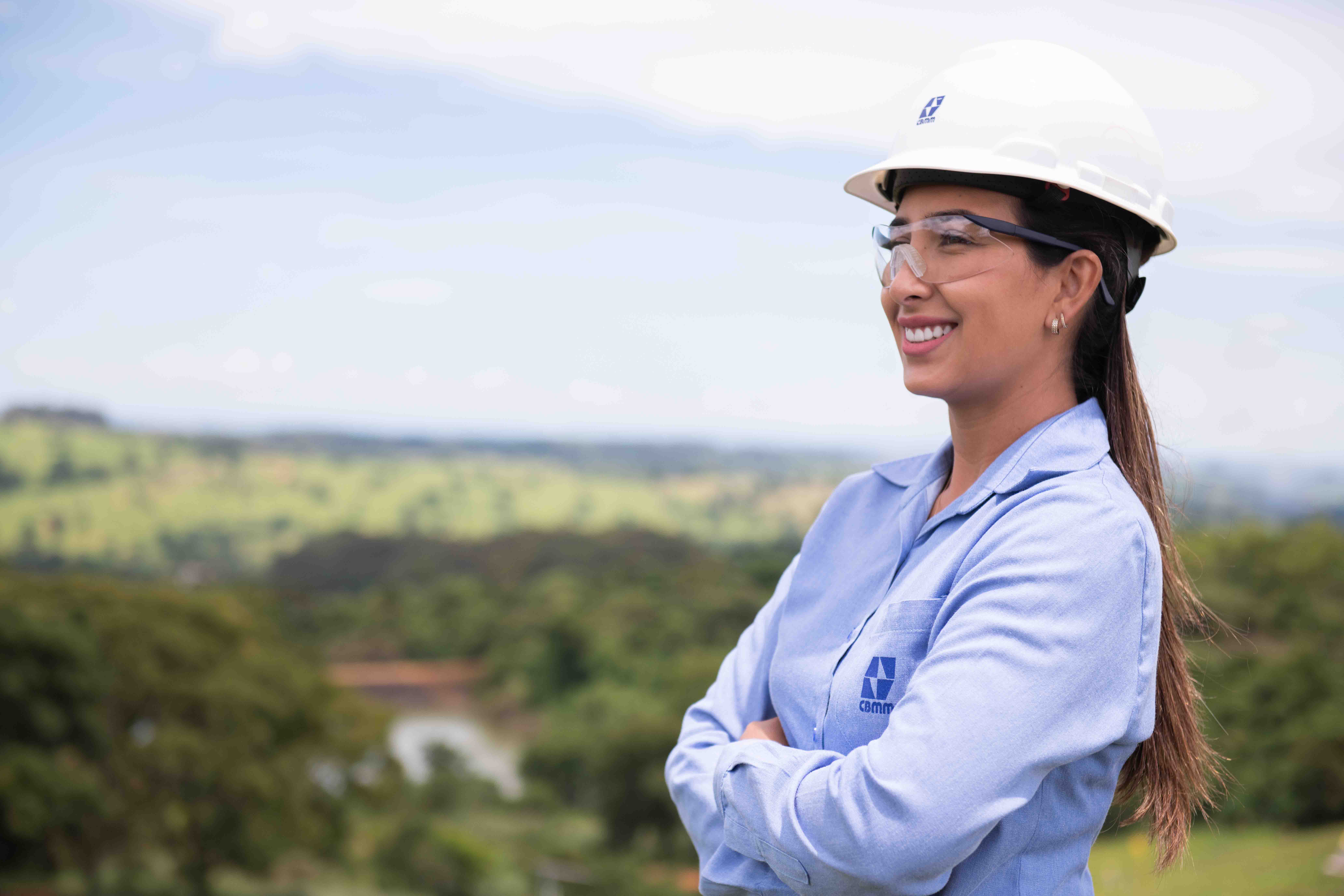 Smiling cross-arm woman with CBMM shirt and protective helmet